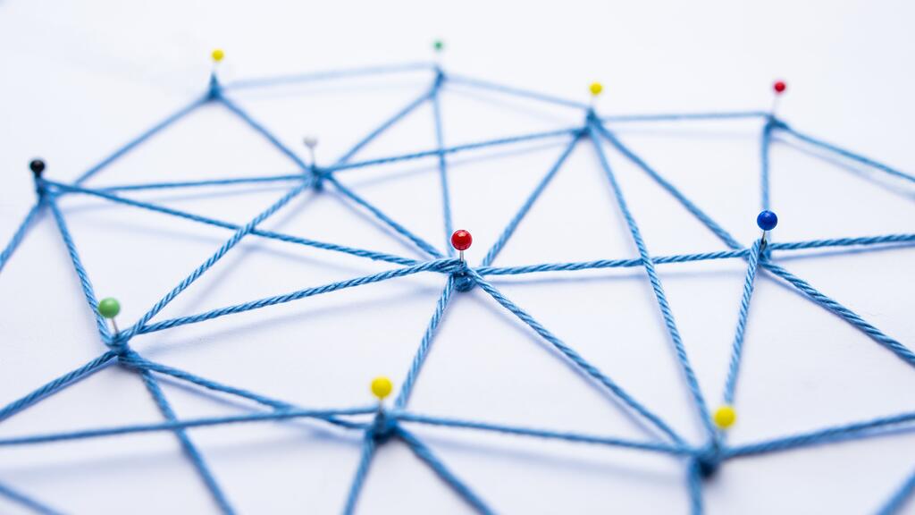 Netzwerk aus Stecknadeln und Faden mit vielen Verbindungen