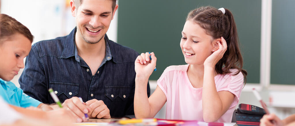 Ein Pädagoge unterstützt Schüler in einer Lernsituation