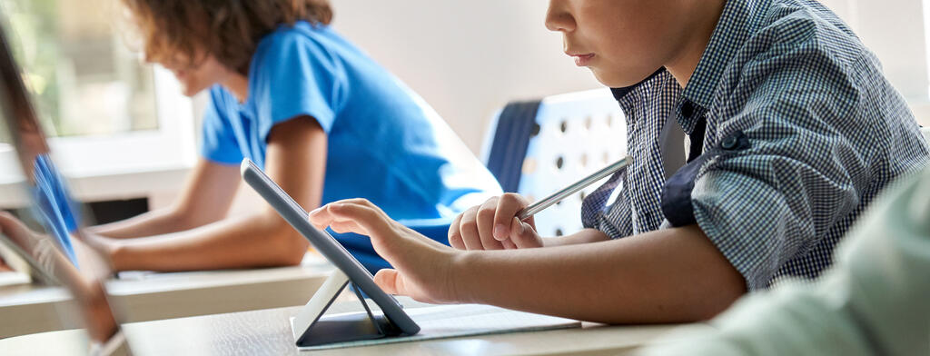 Schülerinnen und Schüler verwenden Tablets im Klassenzimmer.